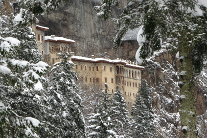 Karla kaplı çam ağaçları arasında Sümela Manastırı